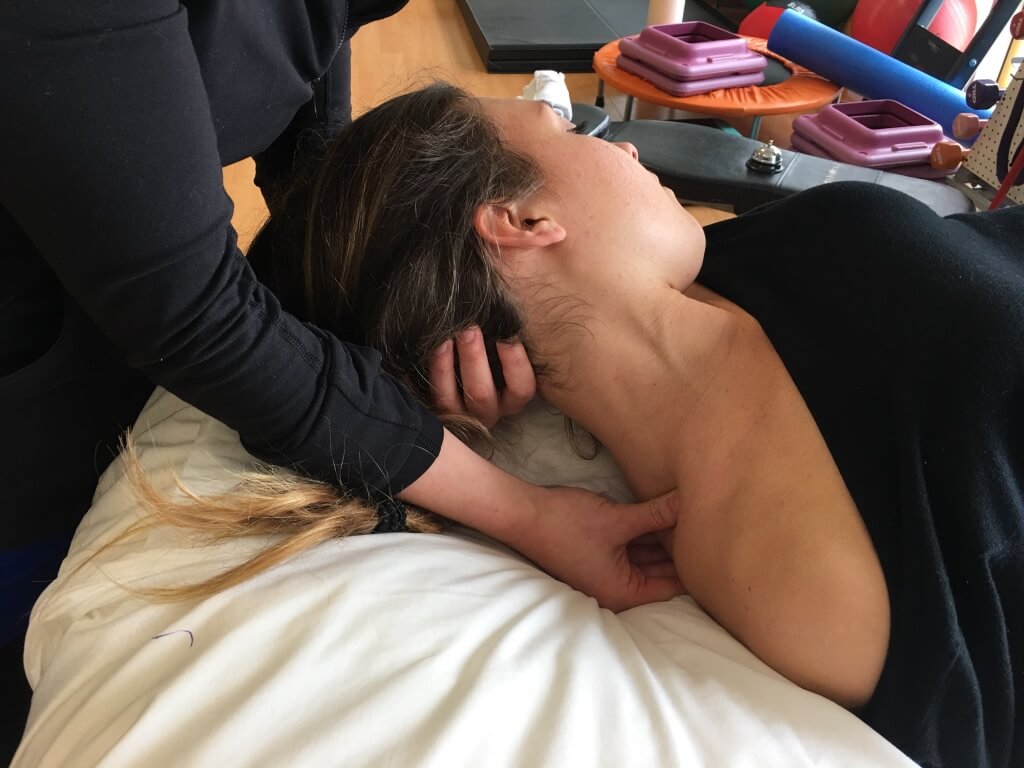 Physiotherapist providing manual therapy for concussions in kids