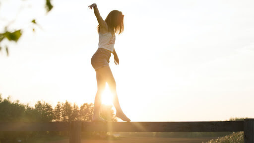 woman balancing on log