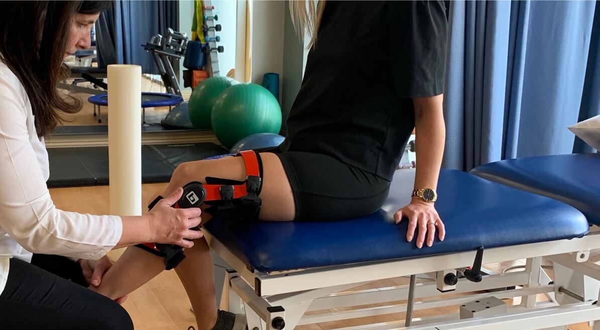 fitting a leg brace on a woman for leg pain, PhysioPlus