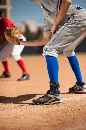Image of a boy wearing an ankle brace while playing baseball.