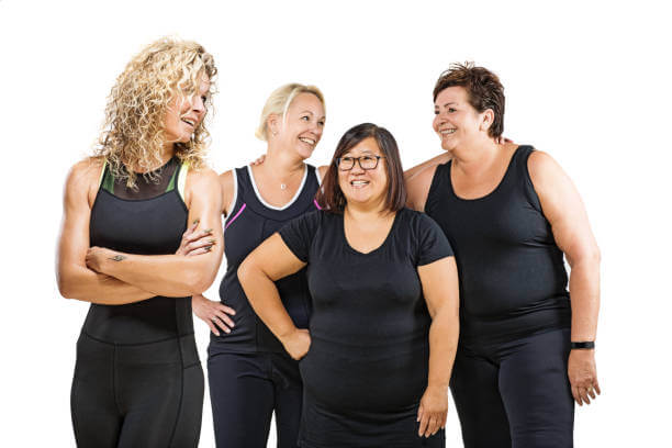 Fitness instructor with a team of overweight middle aged women posing for group pic