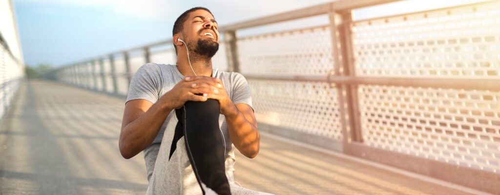 Runner holding knee after injury