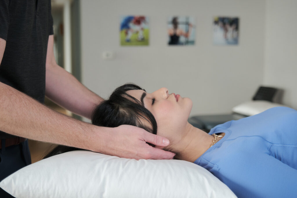 Dr. Jeff Belgue, Registered Chiropractor, treats patient for head and neck pain.