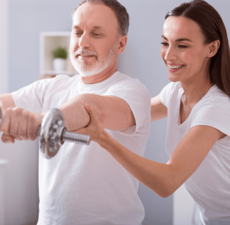 a physiotherapist helping a patient perform his exercises with a dumbell during an in-home physiotherapy session