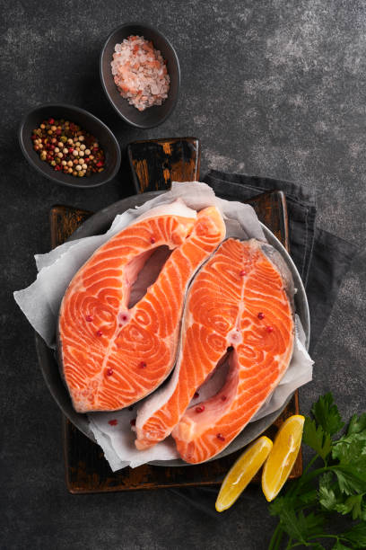 Salmon. Raw salmon steak. Fresh raw salmon fish with cooking ingredients, herbs and lemon
